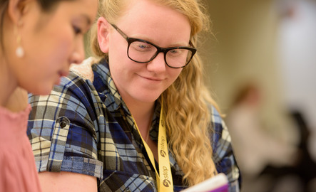 A tutor helps a fellow student in the library