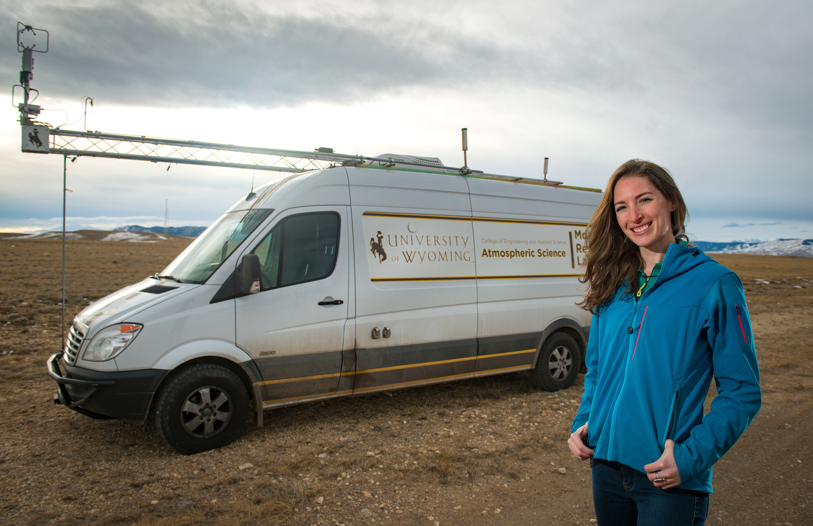 Researcher poses outside of research vehicle