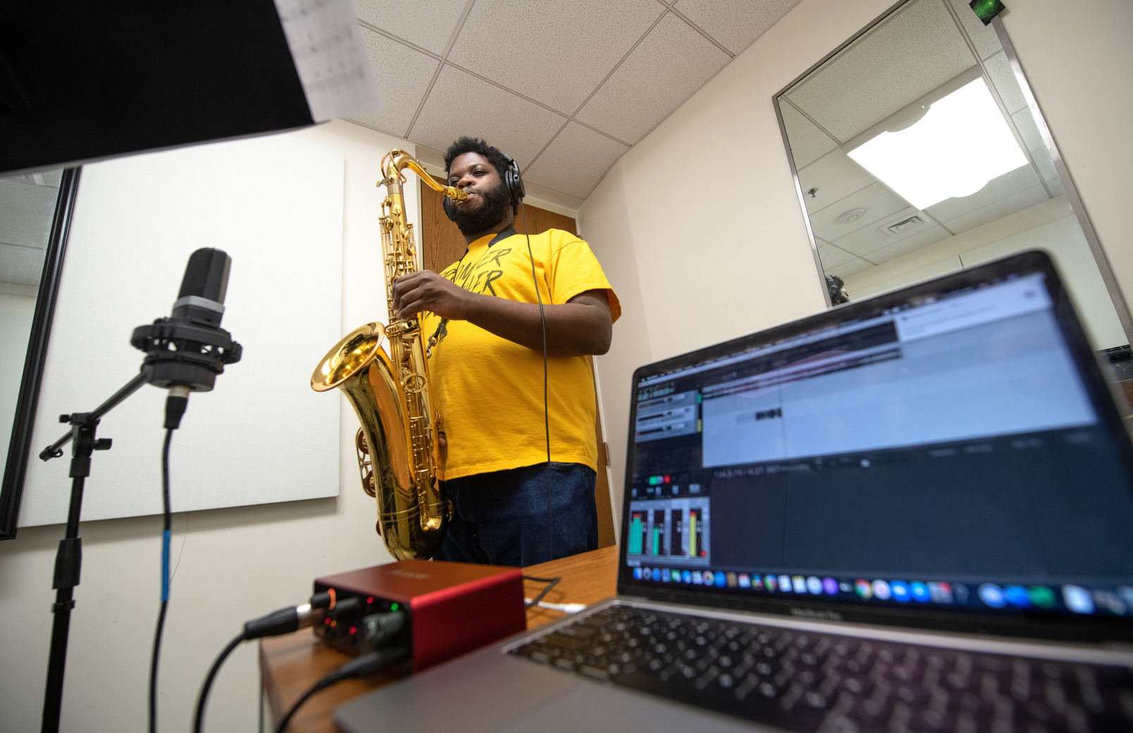 Student playing saxophone and recording himself with audio technology