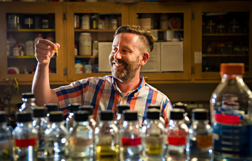 Person looking at vial and test tubes