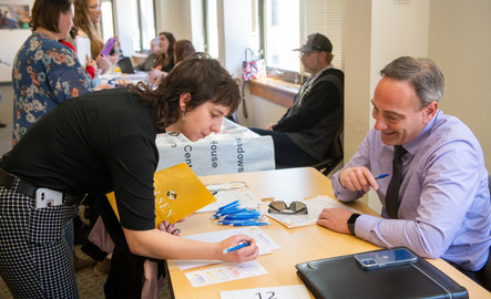A student signs a paper on a vendor's table