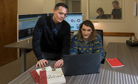 Two researchers look at a computer together