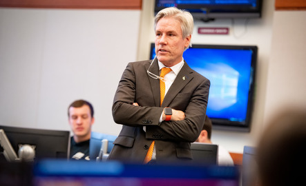 A professor listens to students in their classroom
