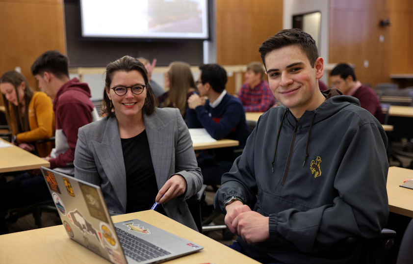 Student and professor posing for photo in classroom