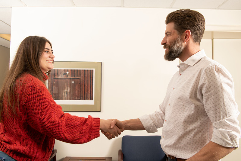 Two people shaking hands in office