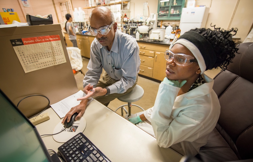 Professor and student in lab working on a computer together