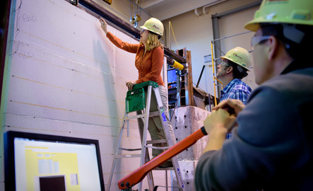 Students and teacher measuring a wall