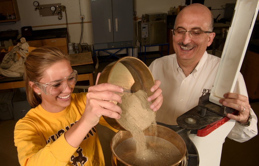 Student and professor working in lab together smiling