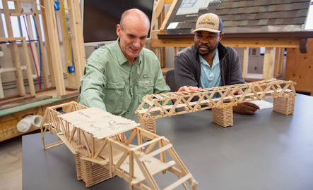 Faculty member and student working with a model structure