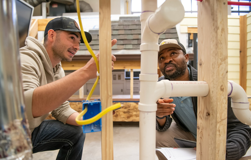 Two students working on a wooden structure together