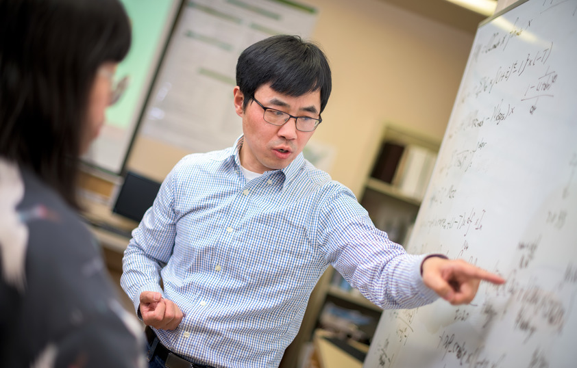 Faculty member pointing at white board