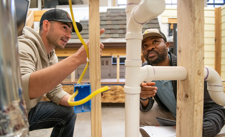 Two students working on a wooden structure together