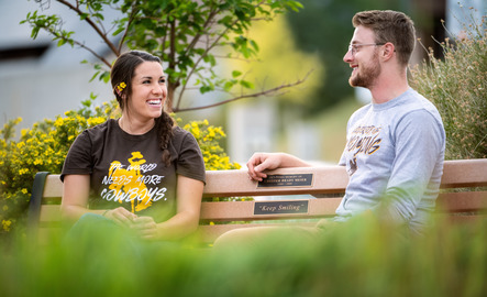 Communication students sitting on bench together