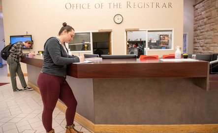 UW student standing at the Office of the Registrar desk