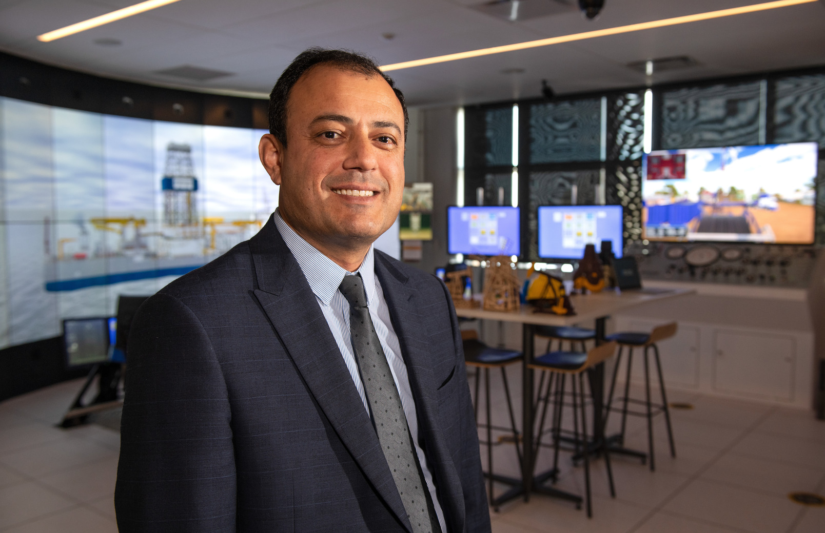 Professor posing for picture in drilling simulator room