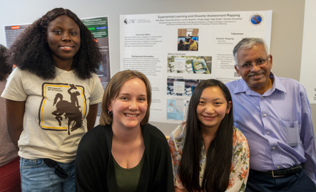 Students and a faculty member smile for a photo