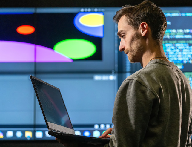Student holding a laptop in lab