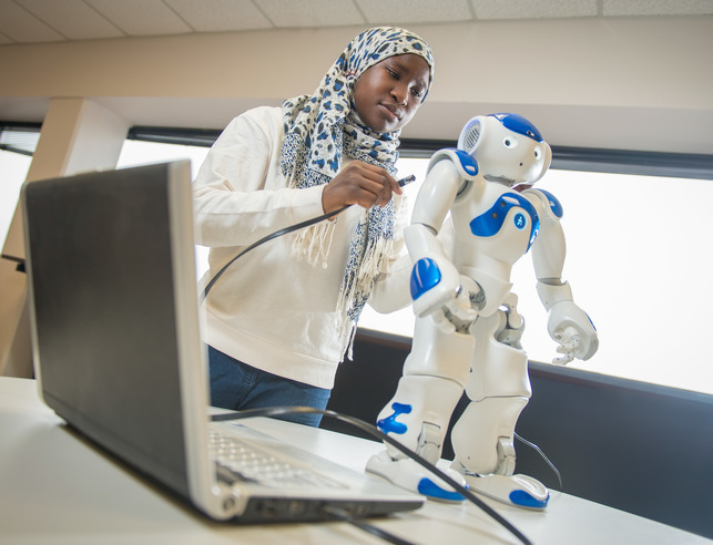 Student with robot and computer