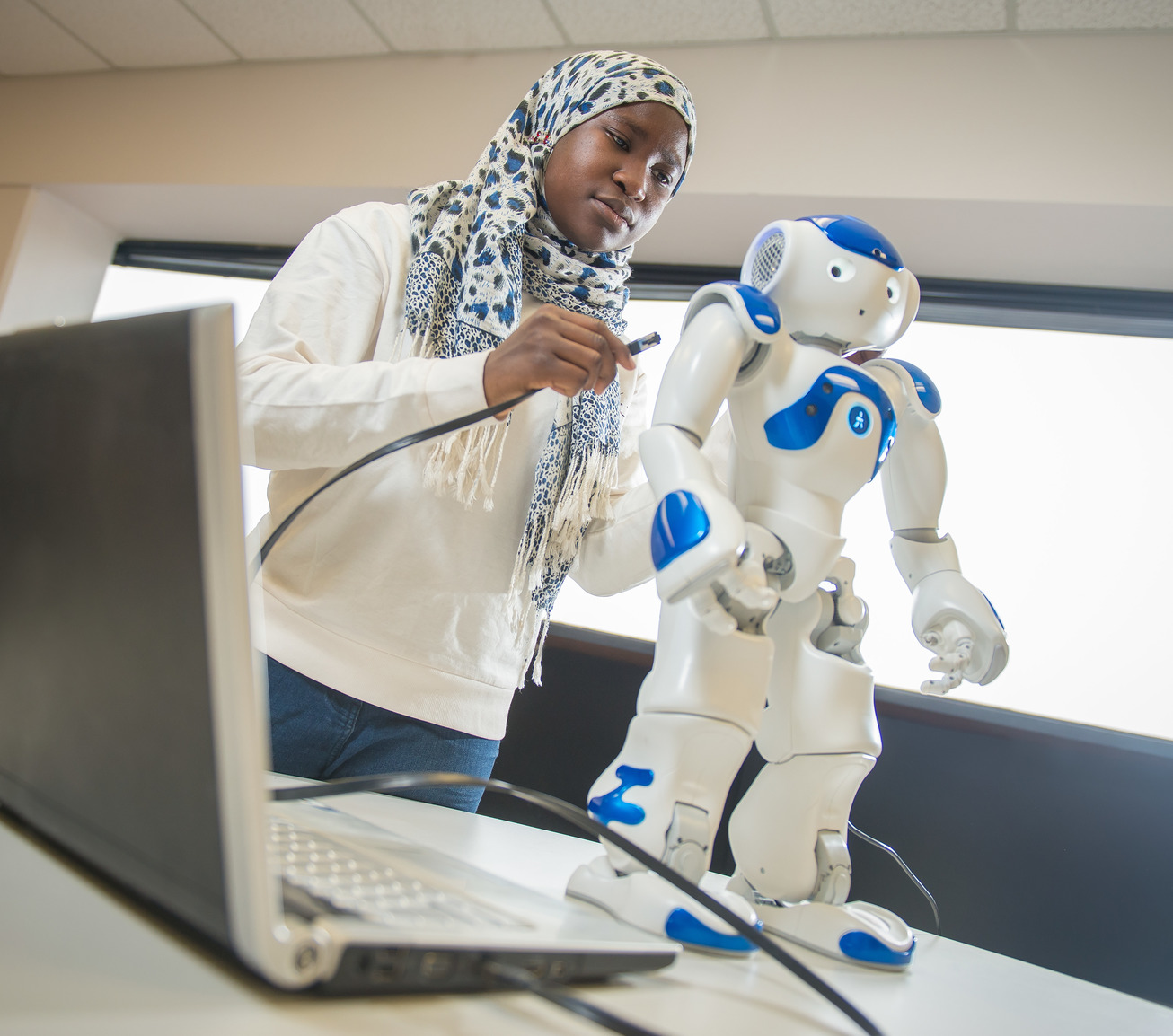 Student with robot and computer
