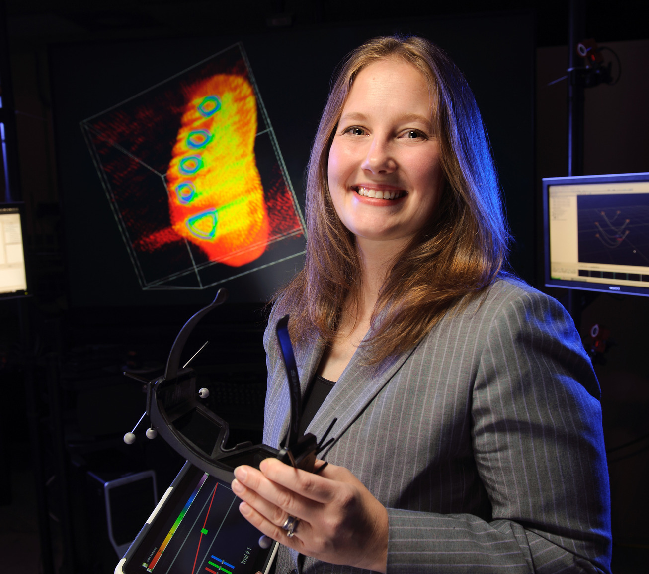 Student in lab and smiling for camera