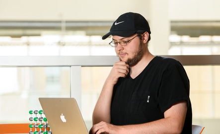 Computer science student working on a laptop