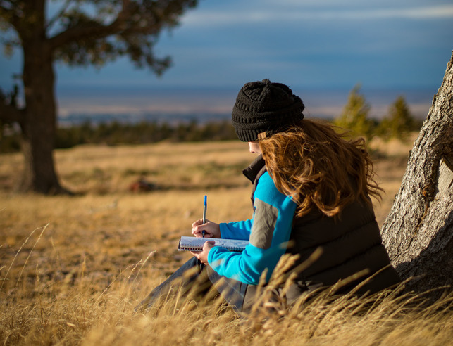 Student writing in a field