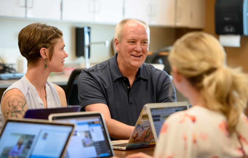 Professor sitting down with students