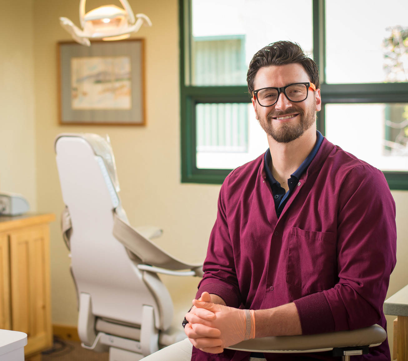 A former UW student stands in their dental exam room