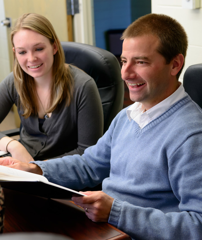A psychology professor has a discussion with doctoral students
