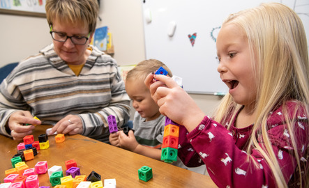 Young children and a teacher playing with blocks