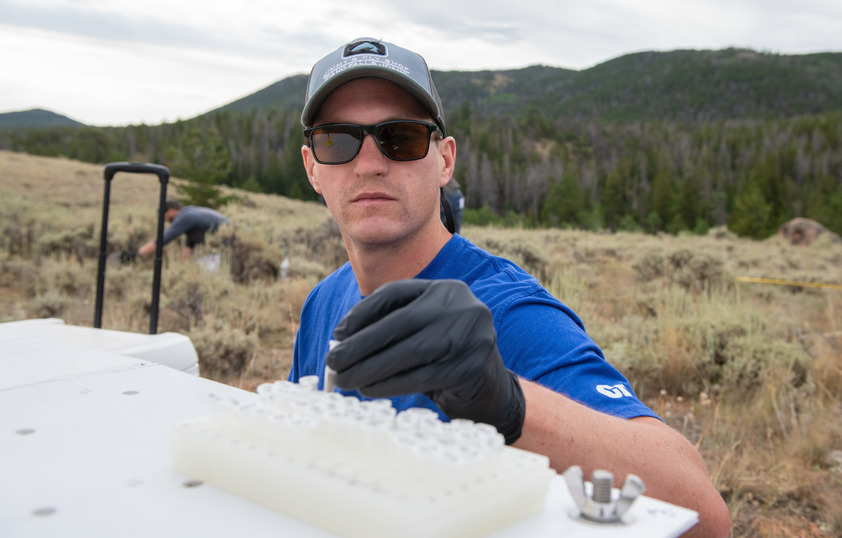 A researcher prepares vials out in the field