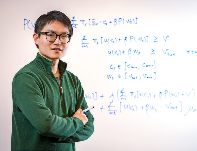 Student posing in front of white board