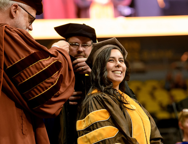 A graduate getting hooded at commencement