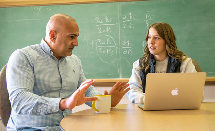 A professor and student work on classwork together