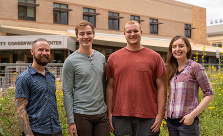 A group of staff members smile for a picture outside of the Berry Center