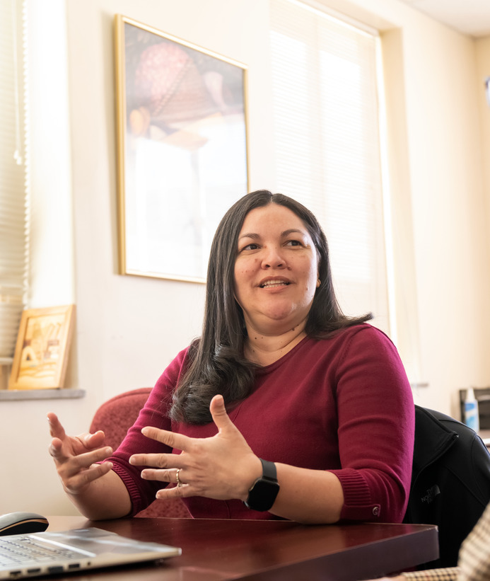 An administrator talks at their desk