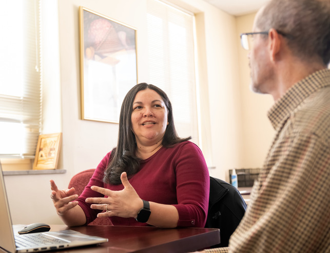 An administrator talks at their desk