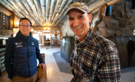 A professor and student smile for a photo at a work site
