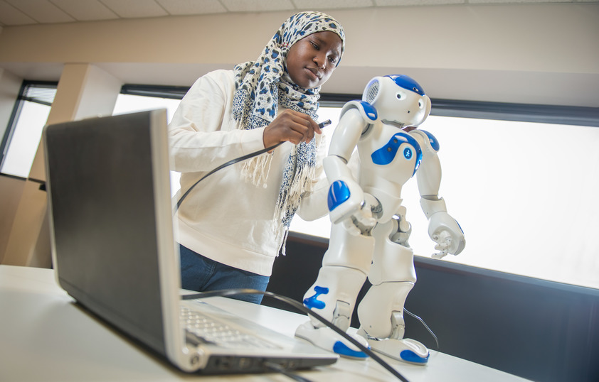 A student plugs in a robot to their laptop