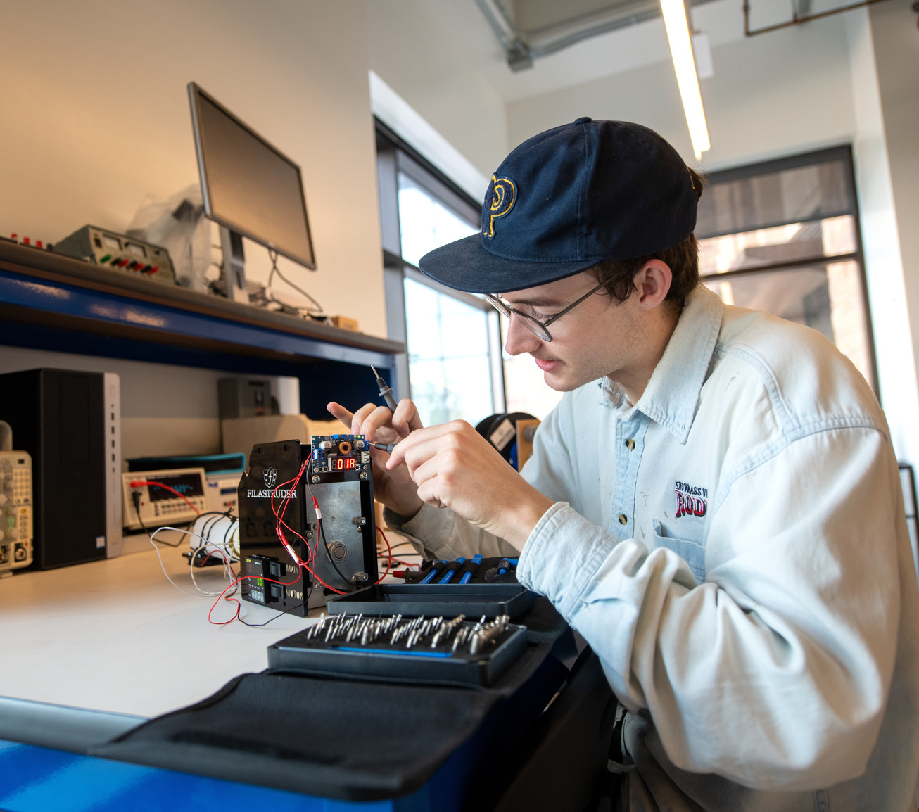 A student works on an electrical engineering project in the makerspace