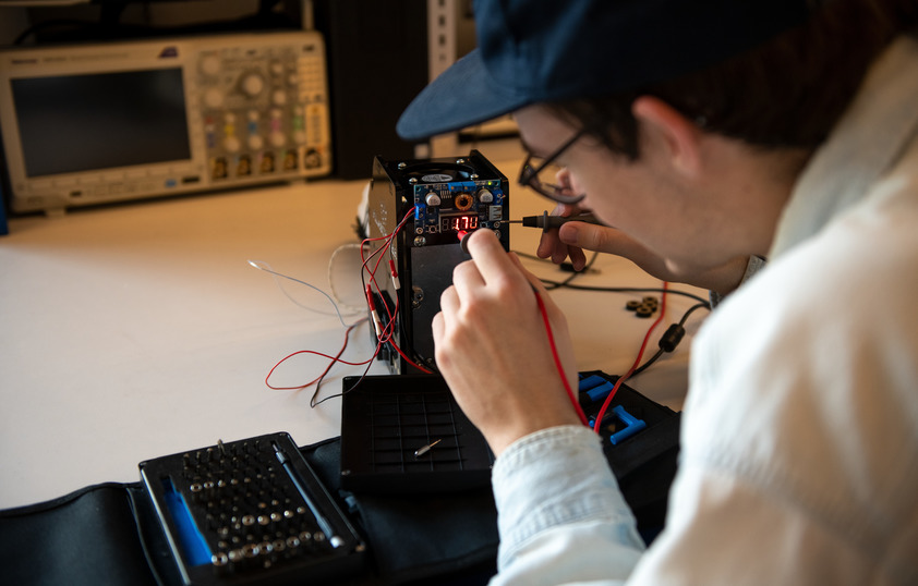 A students works on piecing together an electrical engineering project