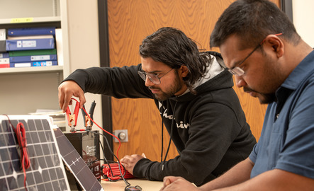 Two students work on their electrical engineering projects