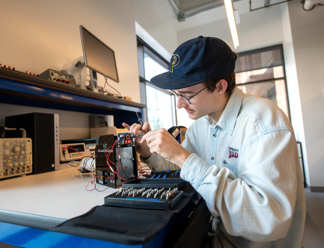 A student works on an electrical engineering project in a lab