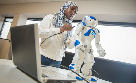 A student plugs in a robot to their laptop