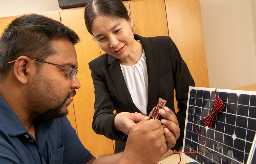 A professor helps a student during lab