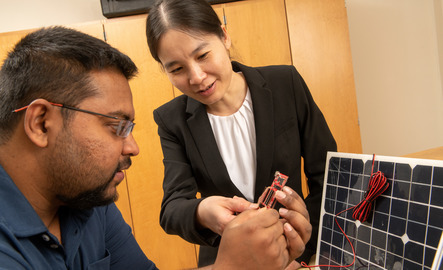 A professor helps a student during lab