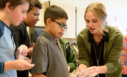 A teacher helps student in a lab