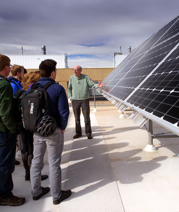 Students and a professor looking at solar panels