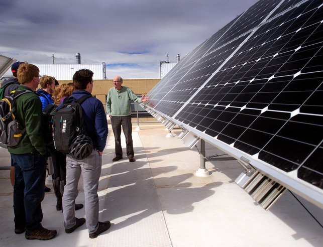 Students and a professor looking at solar panels