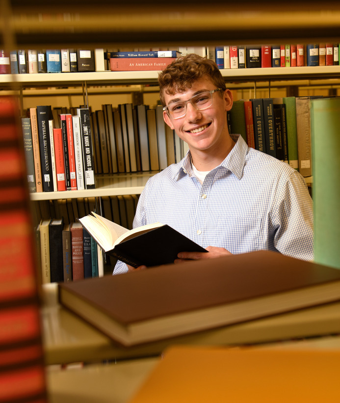 Student opening a book in the library